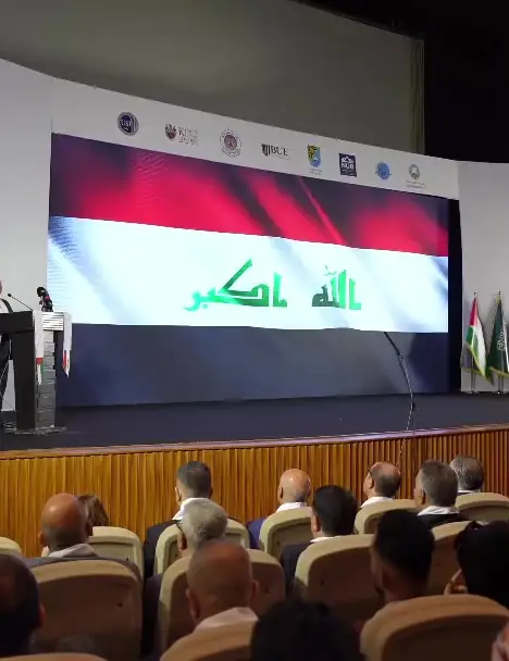 منصة حفل افتتاح مؤتمر UNC IDC والعلم العراقي على الشاشة